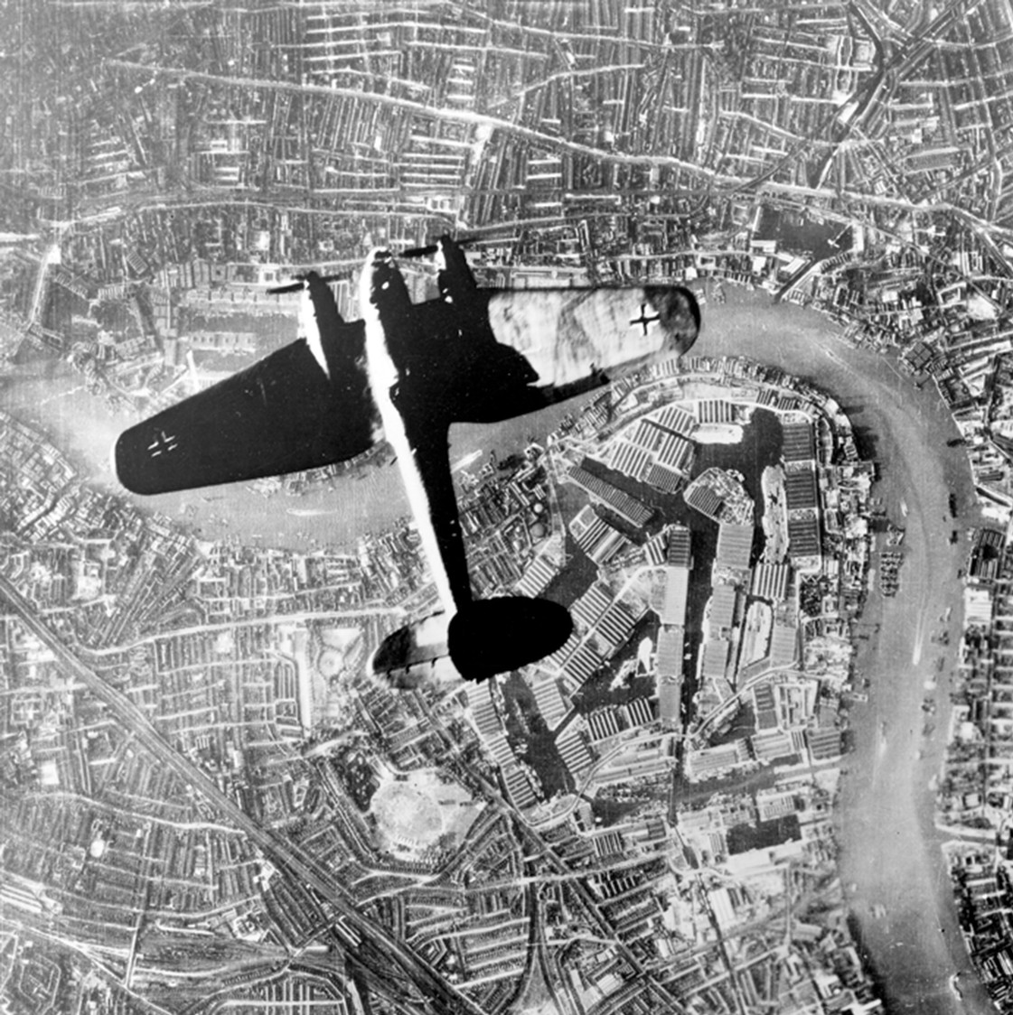 1940年「不列颠空战」期间,一架德国空军亨克尔 He 111 轰炸机掠过英国伦敦东区的沃尔平上空。机头标志性的玻璃驾驶舱「阶梯式」设计与密集的防御机枪清晰可见,是德国空军在空袭英国本土战役中的重要作战机型。