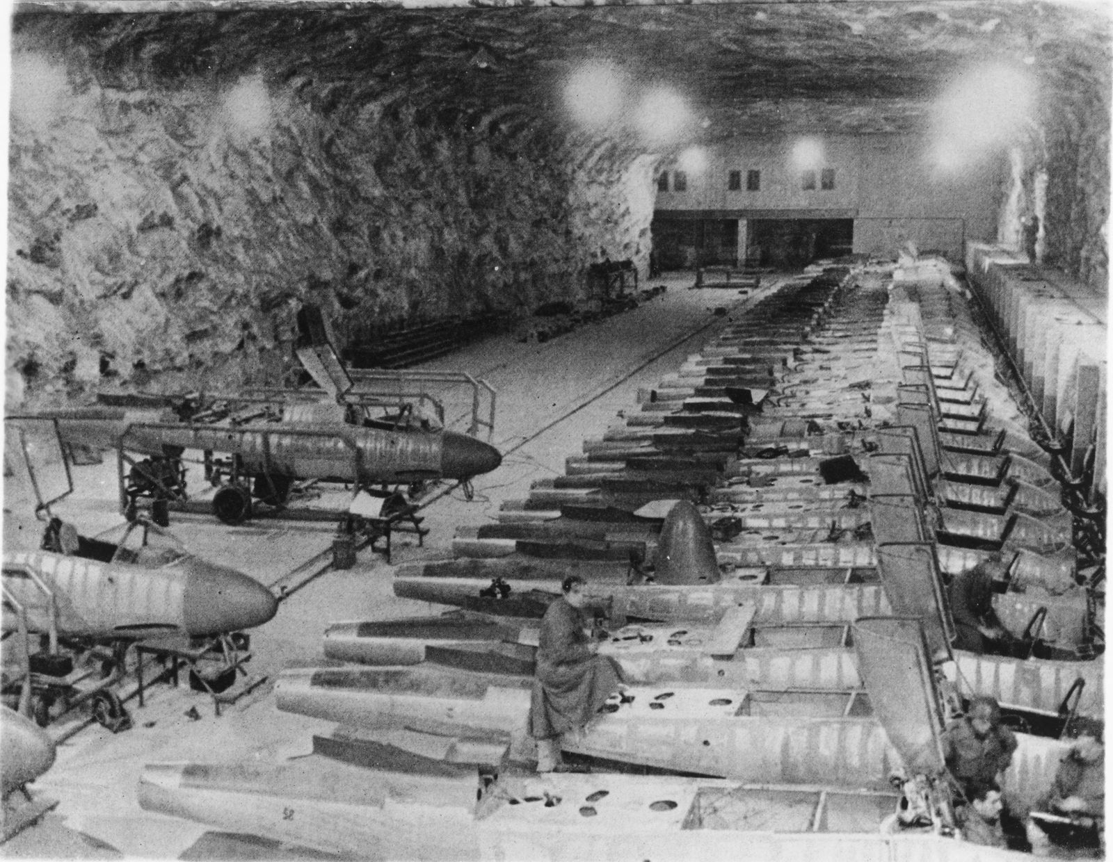 1945年德国地下飞机制造车间内的亨克尔 He 162 生产场景。为躲避盟军战略轰炸,部分总装被转移至地下洞穴与隐蔽厂房,但多数机体直至战争结束仍未能及时完工或交付作战部队。