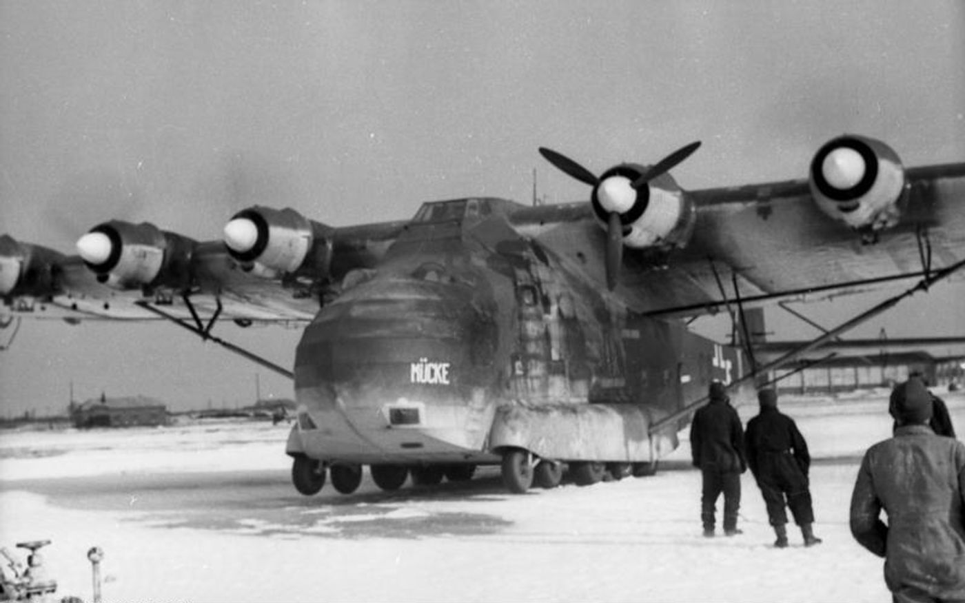 1942年，东线战场上一架梅塞施密特 Me 323「巨人」停在被夺占的苏联机场停机坪上。在「巴巴罗萨行动」启动后的东线战争中，这种庞大的运输机承担起重型物资的空运任务，利用夺取的机场向前线部队运送车辆、火炮与补给，机头张开的货舱门可直接装载大尺寸货物，极大缓解了东线铁路与公路运输的压力。