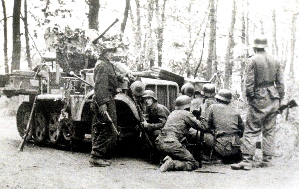 1944年秋天,在西线战场上作战的德军某装甲师的一辆Sd.Kfz.10/5半履带防空炮车。车前是利用炮车作掩护的一队德军士兵。