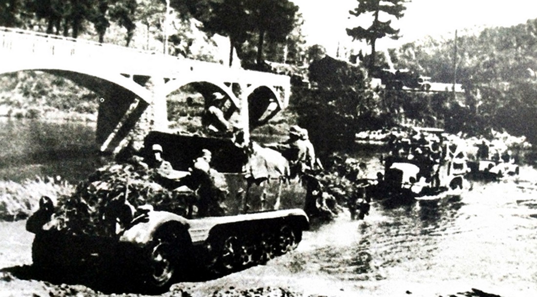 1940年5月,西线战场法国,德军一辆3吨级Sd.Kfz.11半履带车拖带着一门105毫米leFH 18榴弹炮和马基路斯M206卡车一起穿越一条小河。