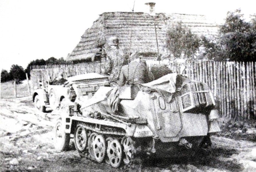 1943年秋天,东线苏联战场,1辆德军(不明单位)的Sd.Kfz.250/3 Ⅰ(Alt)型半履带装甲通讯指挥车正从一个村庄驶过。