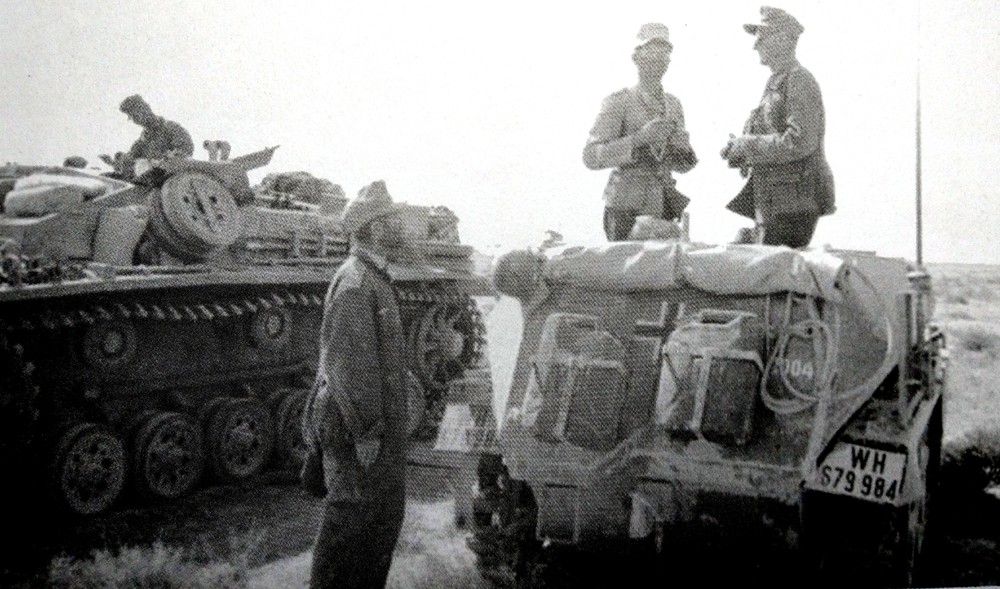1942年初,德国非洲军团属下第90轻装师师长乌尔里希·克里曼(Ulrich Kleemann)少将在自己的一辆Sd.Kfz.250/3 Ⅰ(Alt)型半履带装甲通讯指挥车上作战斗指示。