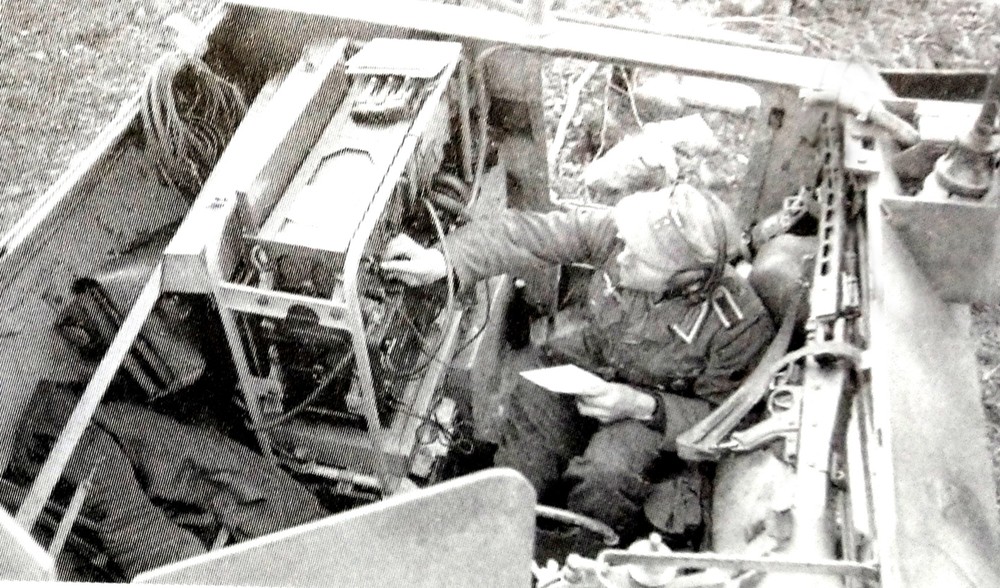 一辆Sd.Kfz.250/3 Ⅰ型半履带装甲通讯指挥车内的通讯员正在操作大功率无线电台进行发报。从图中可见,此型车厢加装了电台后,空间就显得较狭窄,通讯员工作时也得侧着身子坐。