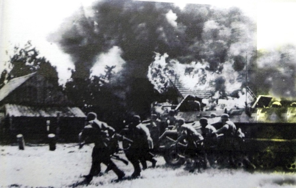 1941年夏天,东线苏联战场,从半履带装甲运兵车下车的德军正在进攻一个苏军据守的村庄,图中靠近士兵的一辆车是Sd.Kfz.251/1 Ausf.B型半履带装甲运兵车,而旁边的一辆是配备37毫米火炮的Sd.Kfz.251/10 Ausf.B型半履带装甲火力支援车。
