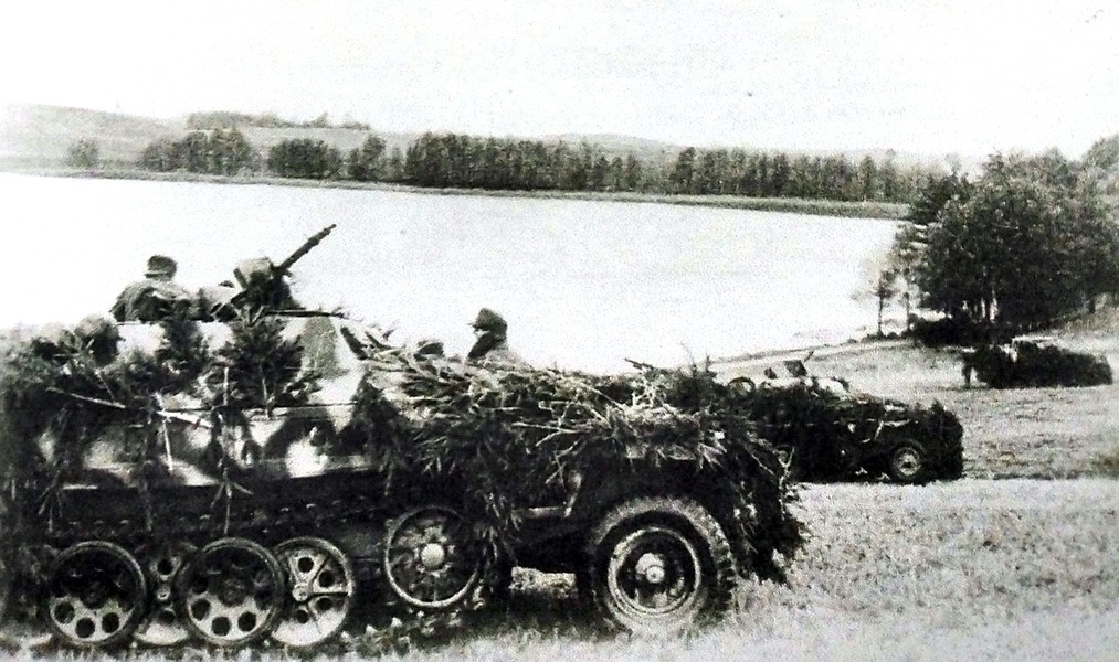 1944年东线战场,一队德军未明单位的Sd.Kfz.251/1 Ausf.D型半履带装甲运兵车正停靠在湖边待命。