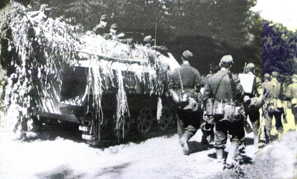 1944年夏天,一辆用树枝作了伪装的Sd.Kfz.251/1 Ausf.D型半履带装甲运兵车伴随着一队德军装甲掷弹兵团士兵从东线战场上撤退。