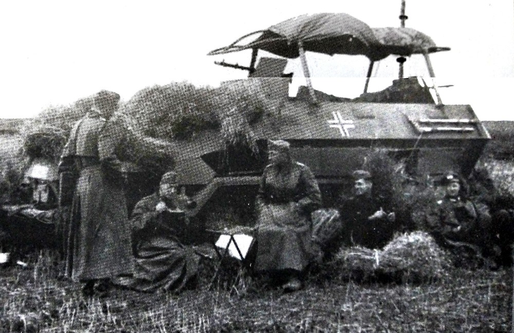 1941年9月,东线苏联战场中部地区,德军1辆Sd.Kfz.251/3(Ausf.A型车体)Ⅳ型半履带装甲通讯指挥车。该车在车厢前后方都安装了一挺带防盾的机枪,还利用天线的框架造了一个雨蓬;车组人员正在车外草地上休息。