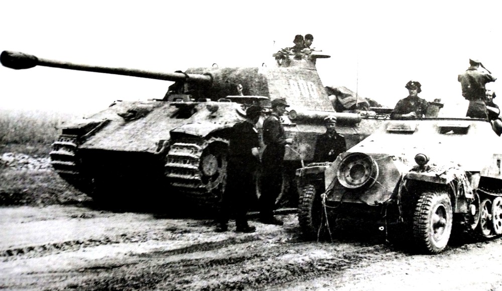 1944年,东线战场波兰地区,德国武装党卫军第5「维京」装甲师坦克部队中的一辆Sd.Kfz.251/3(Ausf.D型车体)Ⅴ型半履带装甲通讯指挥车。车旁是一辆德军虎式坦克。