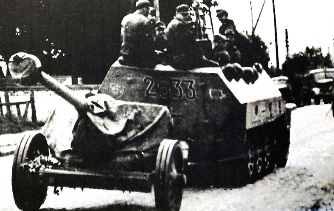 1944年夏天,西线战场,一辆Sd.Kfz.251/4 Ausf.D型半履带装甲火炮牵引车牵引着一门75毫米口径Pak 40型中型反坦克炮行驶在公路上。