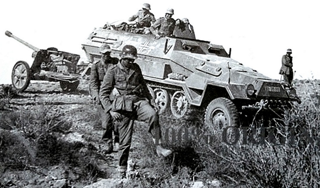 1942年,北非战场上一辆隶属德国非洲军团的Sd.Kfz.251/4 Ausf.A型半履带装甲火炮牵引车牵引着一门50毫米Pak 38型轻型反坦克炮在崎岖的路上行进。