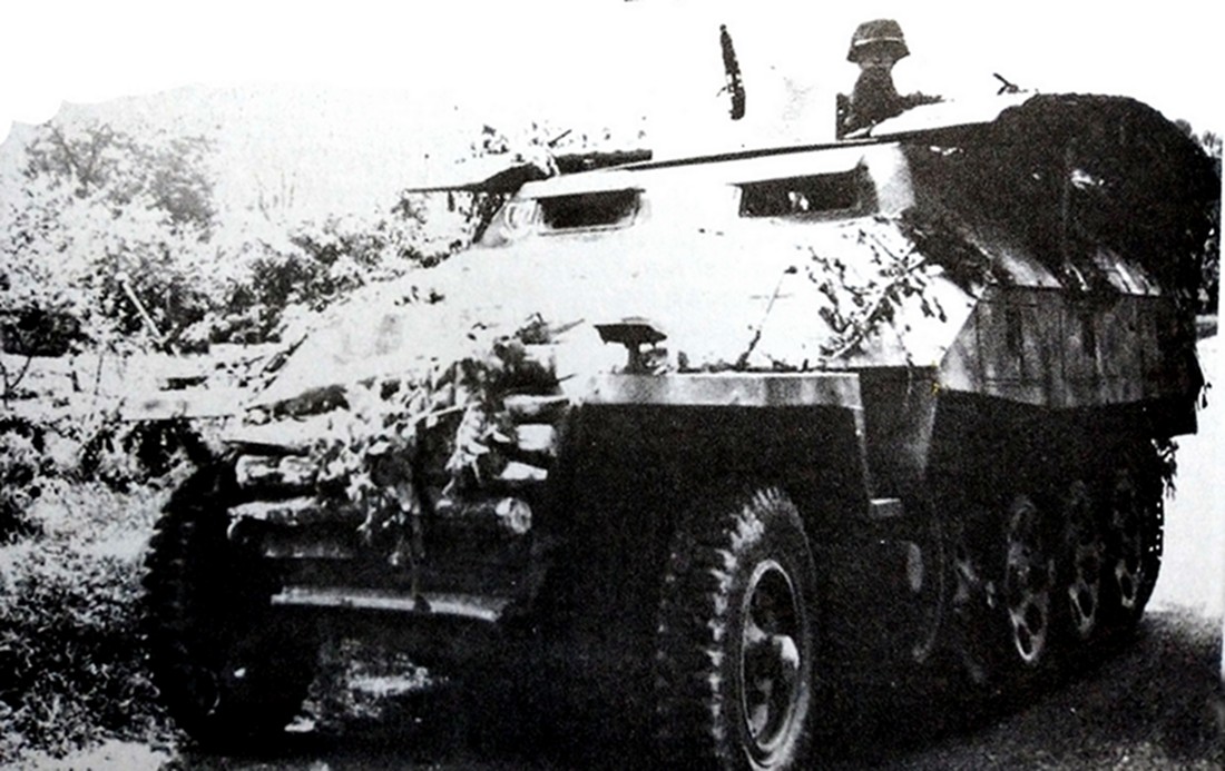 1944年,西线战场上一辆正在公路上行进的德军Sd.Kfz.251/7 Ausf.D型半履带装甲工兵突击车。该车车厢上方两侧搭载着工兵桥,车身已用树枝作了伪装,车头还捆绑了不少作铺路用的木条。