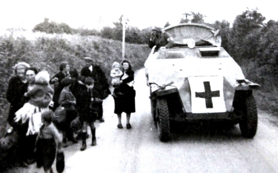 1944年春天,一辆德军Sd.Kfz.251/8型半履带装甲救护车正与一群难民一起向后方撤退。