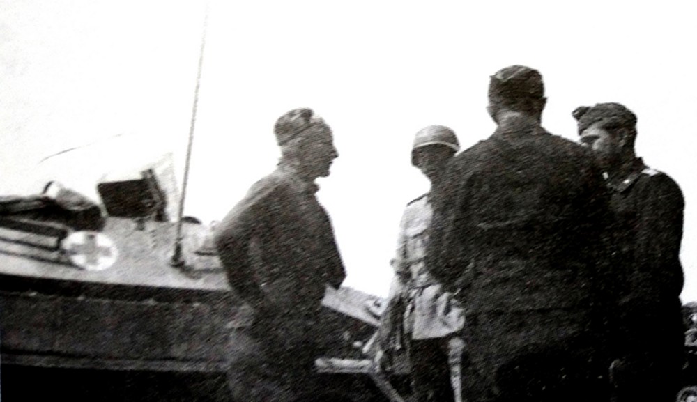 1941年,东线苏联战场,站着的几个德军官兵后面是一辆德军用251 B型车体改装的救护车,该车还保留着前置的机枪防盾,显然是属于在战场上临时改装的野战型半履带装甲救护车。