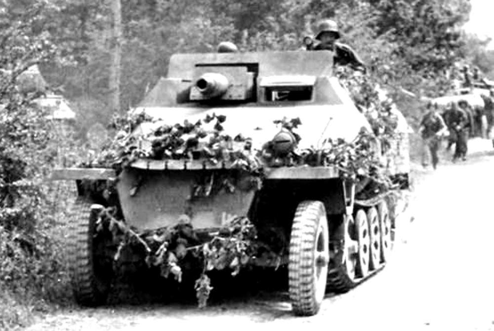 德军一辆Sd.Kfz.251/9 Ausf.D型半履带装甲炮车随德军部队一起向前线进发。