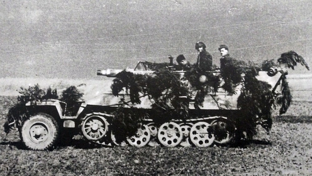 德军一辆行进中的Sd.Kfz.251/9 Ausf.D型半履带装甲炮车,炮车车身上已用树枝作了伪装,以防敌方飞机突袭。