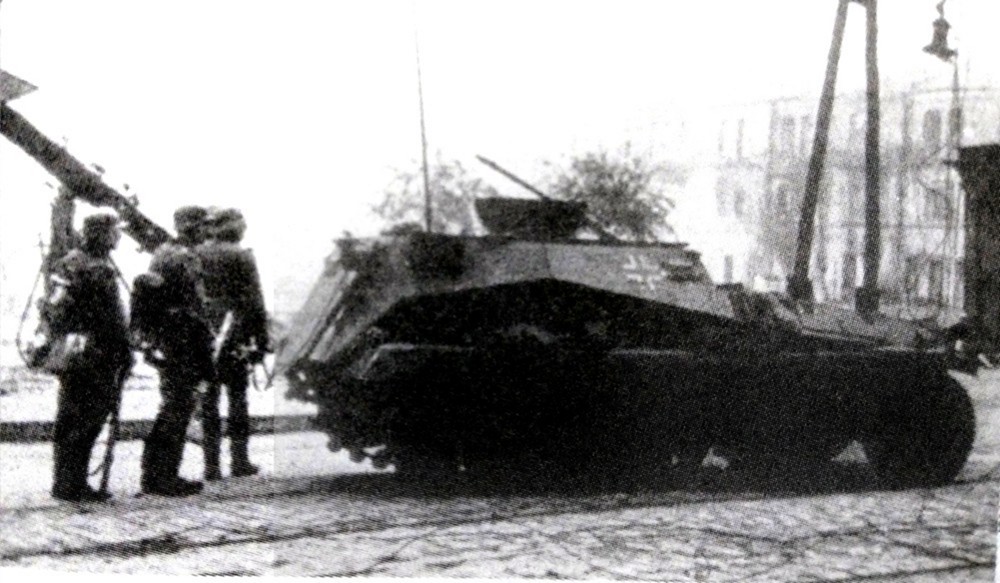 1942年,东线苏联战场,一辆253型半履带装甲炮兵观测车正在与德军步兵一起在某城市街道上向前挺进。