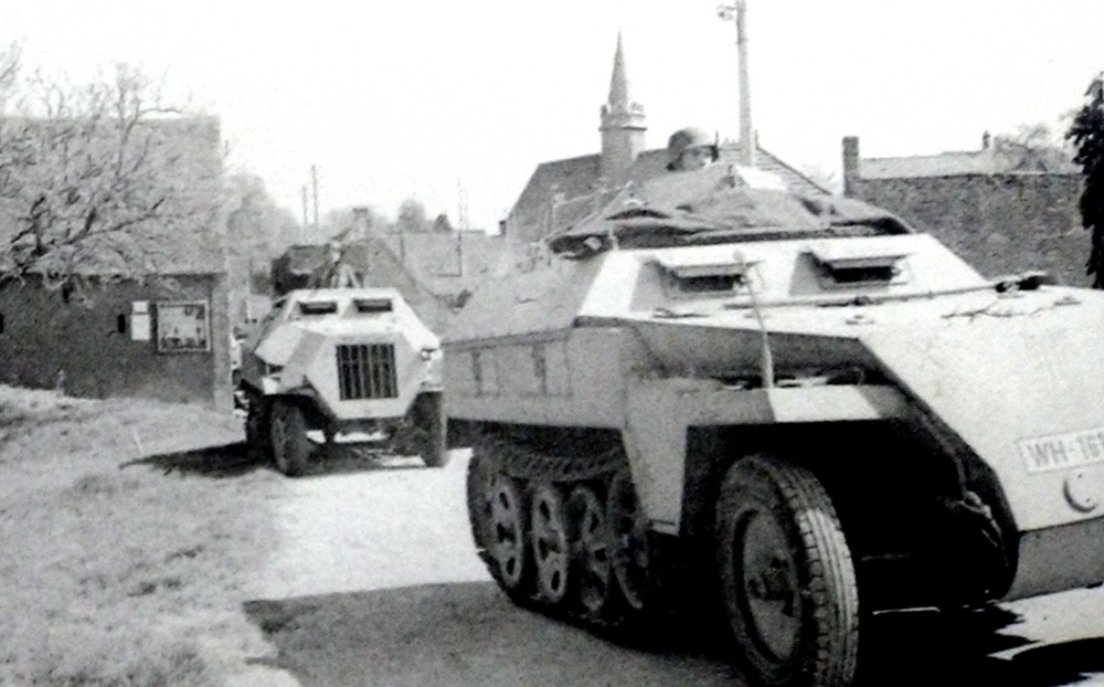 1944年4月,一辆不明单位的德军装甲师属装甲炮兵团的Sd.Kfz.250/4型(采用Neu新车体改装)半履带装甲炮兵观测车,正与德军装甲炮兵部队的车辆一起行驶穿过一村庄。