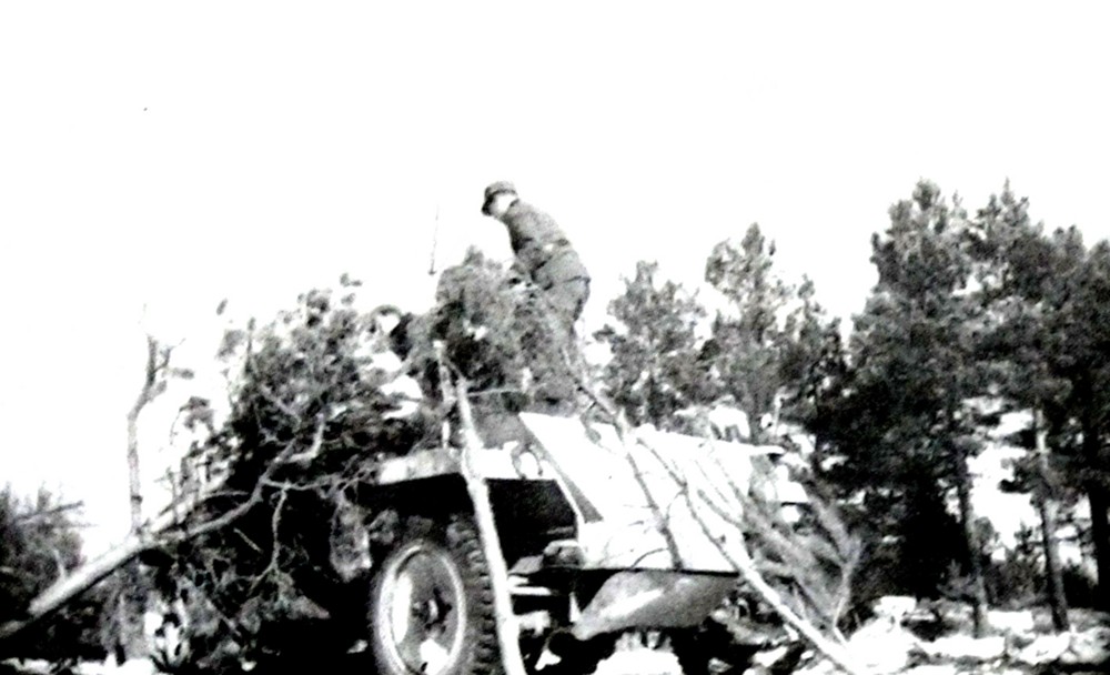 1944年,德军一辆Sd.Kfz.250/4型(采用Neu新车体改装)半履带装甲炮兵观测车的车组乘员正在用树枝为车体作伪装掩护。