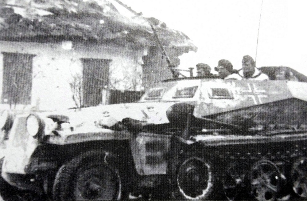 1943年冬天,东线苏联战场,一辆隶属德国武装党卫军炮兵部队的Sd.Kfz.250/12型(采用Alt旧车体改装)半履带装甲炮兵观测车正驶过一个俄罗斯村庄,由于是在行进中,该车收起了潜望镜,并在车厢前部用高射机枪吊架安装了一挺MG34机枪,以作行进中的警戒。