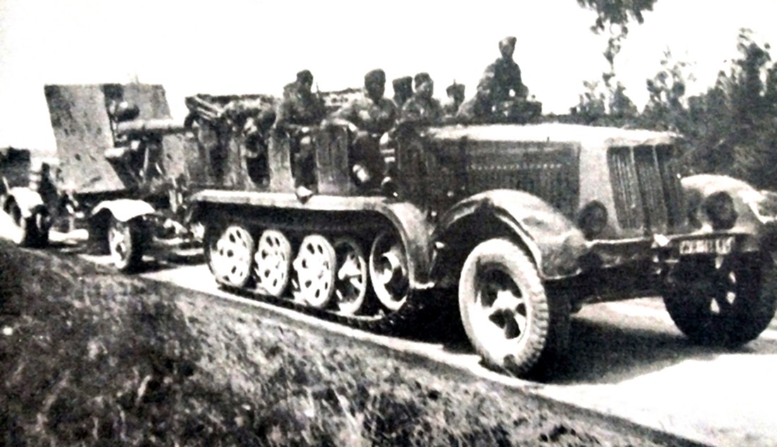 一辆德军8吨级Sd.Kfz.7半履带牵引车正拖挂着Sd.Anh.201拖车及拖车上的88毫米Flak 18高射炮在公路上行进。将88毫米高射炮改作平射,其凶悍的火力的确是坦克与坚固工事的克星,因此这种88高炮通常会配备给德军的装甲部队,并搭载在Sd.Anh.201平台上由牵引车牵引跟随德军装甲部队行动。