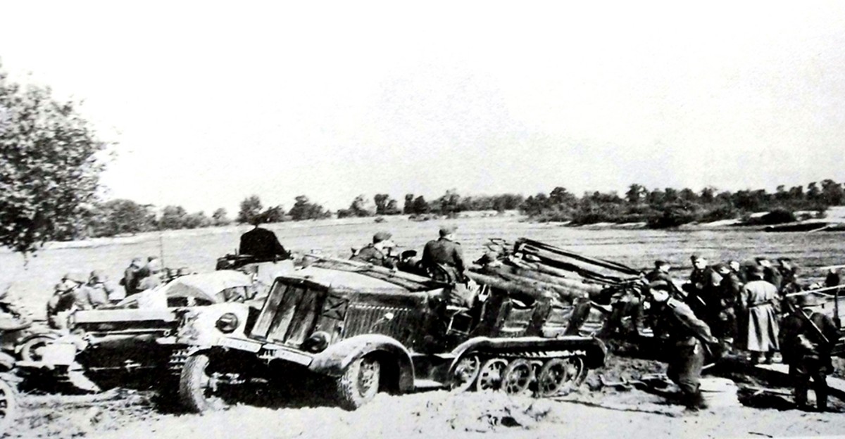 1941年7月,东线苏联战场,跟随装甲部队行动的一辆德军Sd.Kfz.7半履带牵引车渡河后停在一辆Ⅱ号坦克旁边。