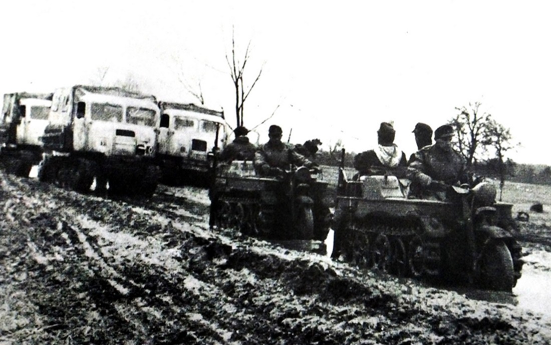 1944年,东线战场,行驶在俄罗斯一条泥泞道路上的德军Sd.Kfz.2小型半履带车,跟在后面的是3辆履带式牵引车。