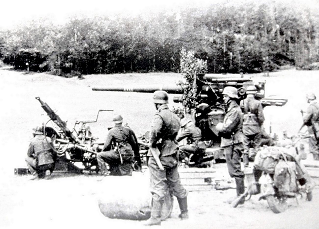 1942年夏天,东线苏联战场,一门隶属德国空军高炮营的88毫米Flak18高射炮班成员已在阵地中作好战斗准备,随时迎击苏军的坦克。注意炮管上的四个「杀伤环」,这是该炮较早前取得的战绩。