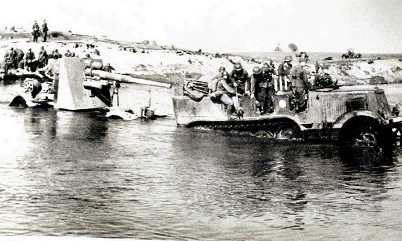 1941年夏天,东线苏联战场乌克兰地区,一辆德军Sd.Kfz.7半履带车牵引着一门88毫米Flak18高射炮正在涉水渡河。由于河水较浅,这门88毫米高炮在201移动台架上亦可安全过河。