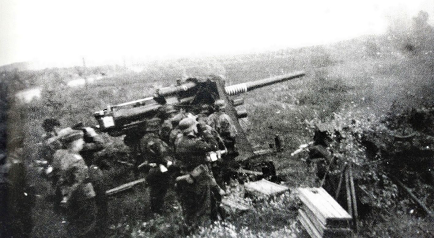 1939年秋,波兰战役,一门德军的88毫米Flak18高射炮正在向地面目标射击。几名军官正观察战况,地面上堆有多个装有三发炮弹的炮弹箱。