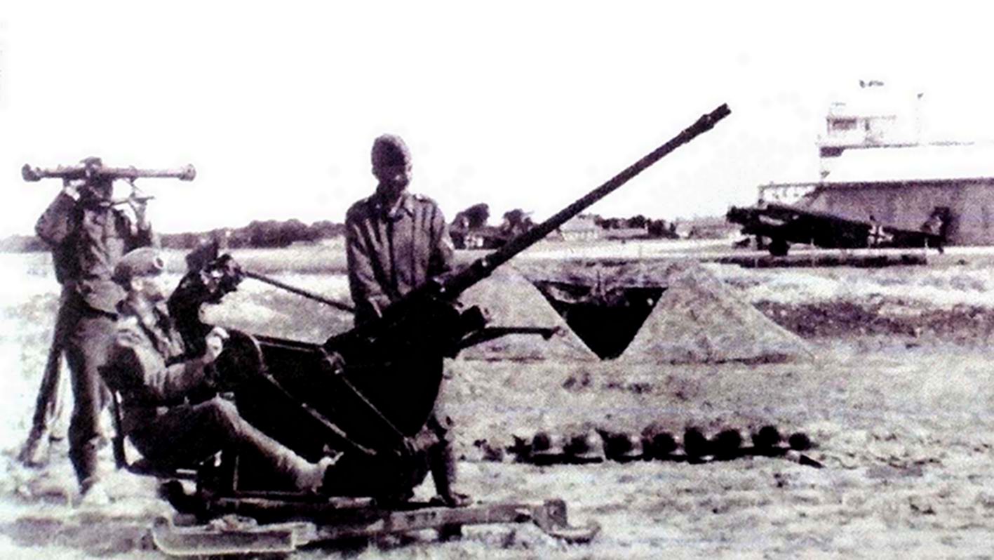战地机场上隶属德国空军防空部队的一门20毫米Flak30型高射炮的炮组人员正在搜寻天空目标,以防机场受到空袭。