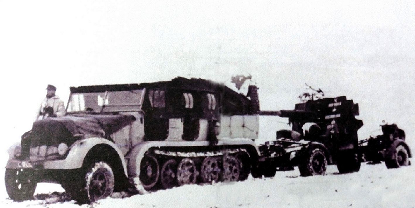 冬季,东线苏联战场,一辆牵引力8吨的Sd.Kfz.7重型半履带装甲车牵引着一门德军88毫米Flak36/37高射炮在雪地中行进。