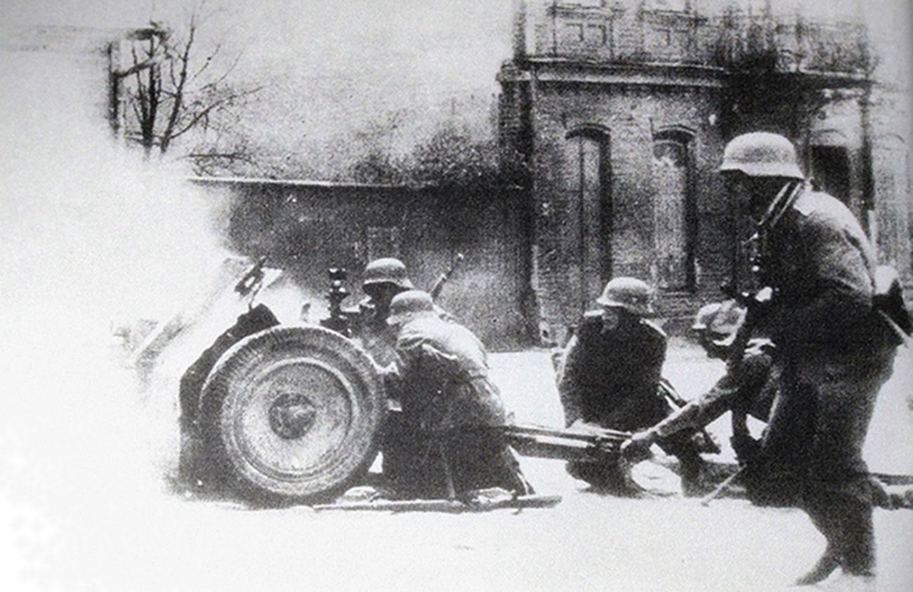 1942年7月,东线苏联战场,在俄罗斯一个小城市的街道上爆发激战,德军一门75毫米le.IG18步兵炮正在射击,用重火力配合步兵的进攻。