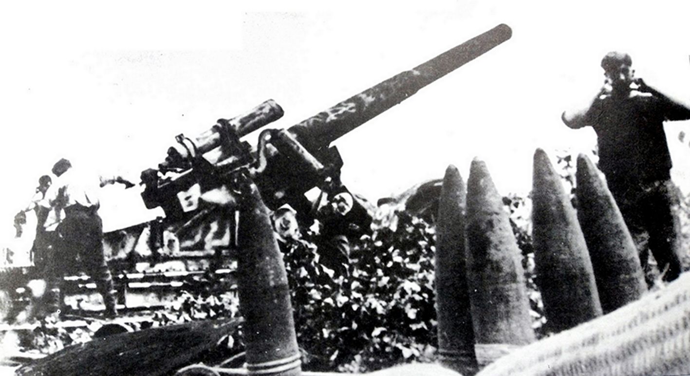 1943年9月，东线苏联战场，德军一门210毫米Mörser18型重型臼炮正在以较低角度进行射击。在阵地上放着的炮弹分别是高爆弹与混凝土贯穿弹，其中高爆弹的初速有565米/秒，重量超过100公斤。