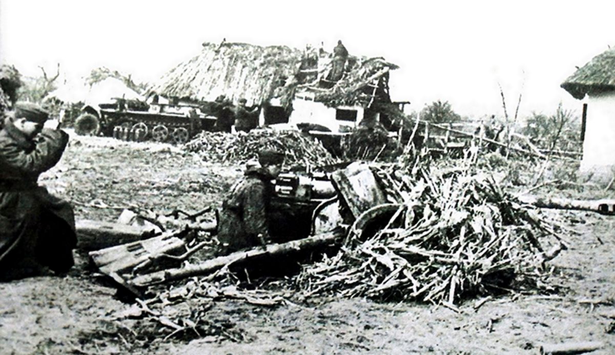 1944年末,东线战场乌克兰南部地区,德国武装党卫军的一个炮兵阵地,阵地上有两门作好伪装的Pak38型反坦克炮。还有一辆牵引火炮的Sd.Kfz.10型半履带装甲车。注意:除炮位有炮长用望远镜对目标进行观察外,还有一名炮兵观察员站在农舍屋顶上进行战地观察。
