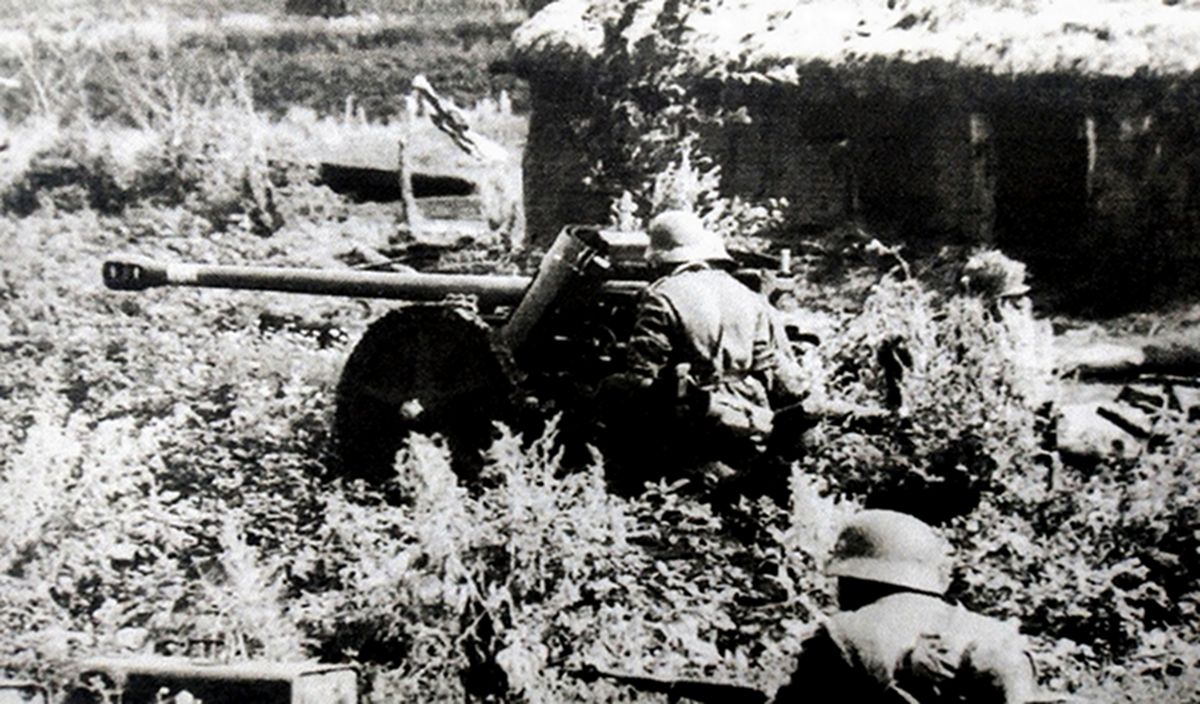 1942年夏天,东线苏联战场,德军一门50毫米Pak38型反坦克炮正在战斗中,为了增加隐蔽性,德军将火炮射击阵地设置在一农舍旁的草丛中。