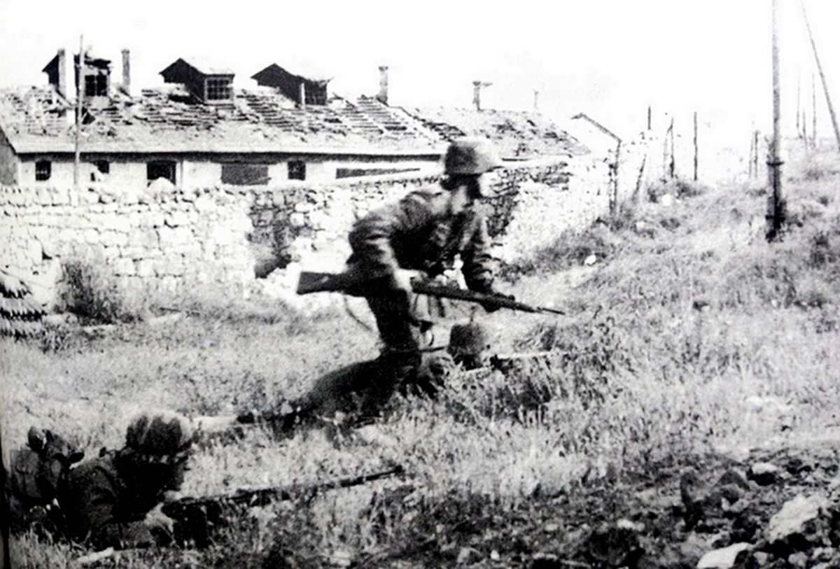 1942年6月,东线苏联战场,德军正在全力进攻塞瓦斯托波尔军事要塞,图为进入要塞郊区的德军,在两名士兵的火力掩护下,另一名士兵端着98K步枪向前跃进。