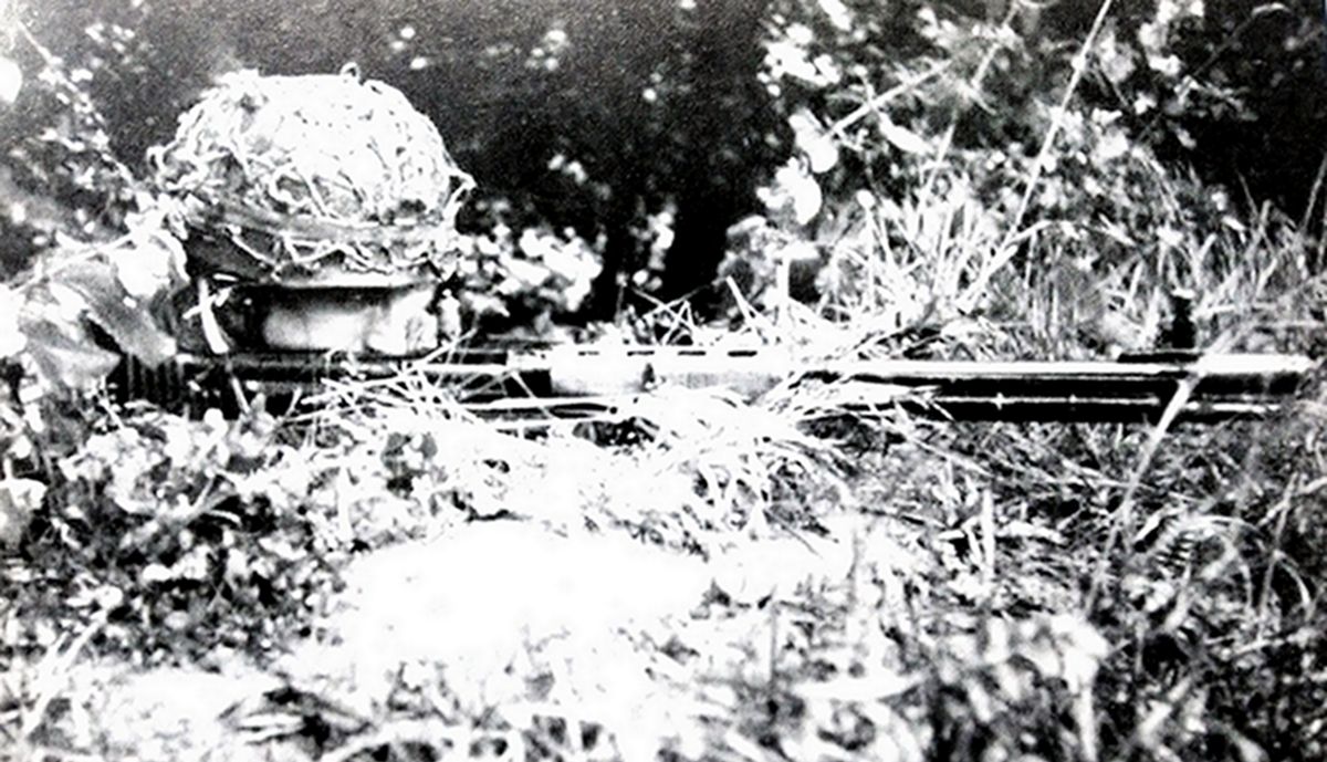 1944年6月中旬,在西线法国战场诺曼底前线,一名德军伞兵伏在草丛中持FG42伞兵步枪对目标瞄准,准备射击。