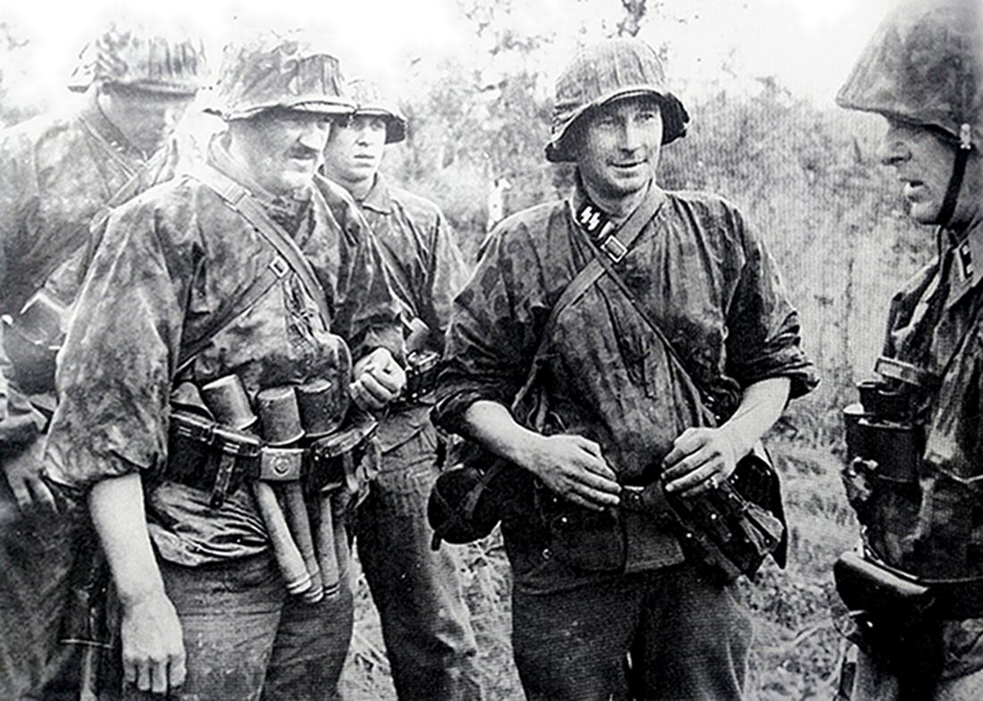 1943年7月,东线苏联战场库尔斯克地区,一群德国武装党卫军官兵在战斗小憩中交谈,其中一名德军腰间插着多枚M24长柄手榴弹。