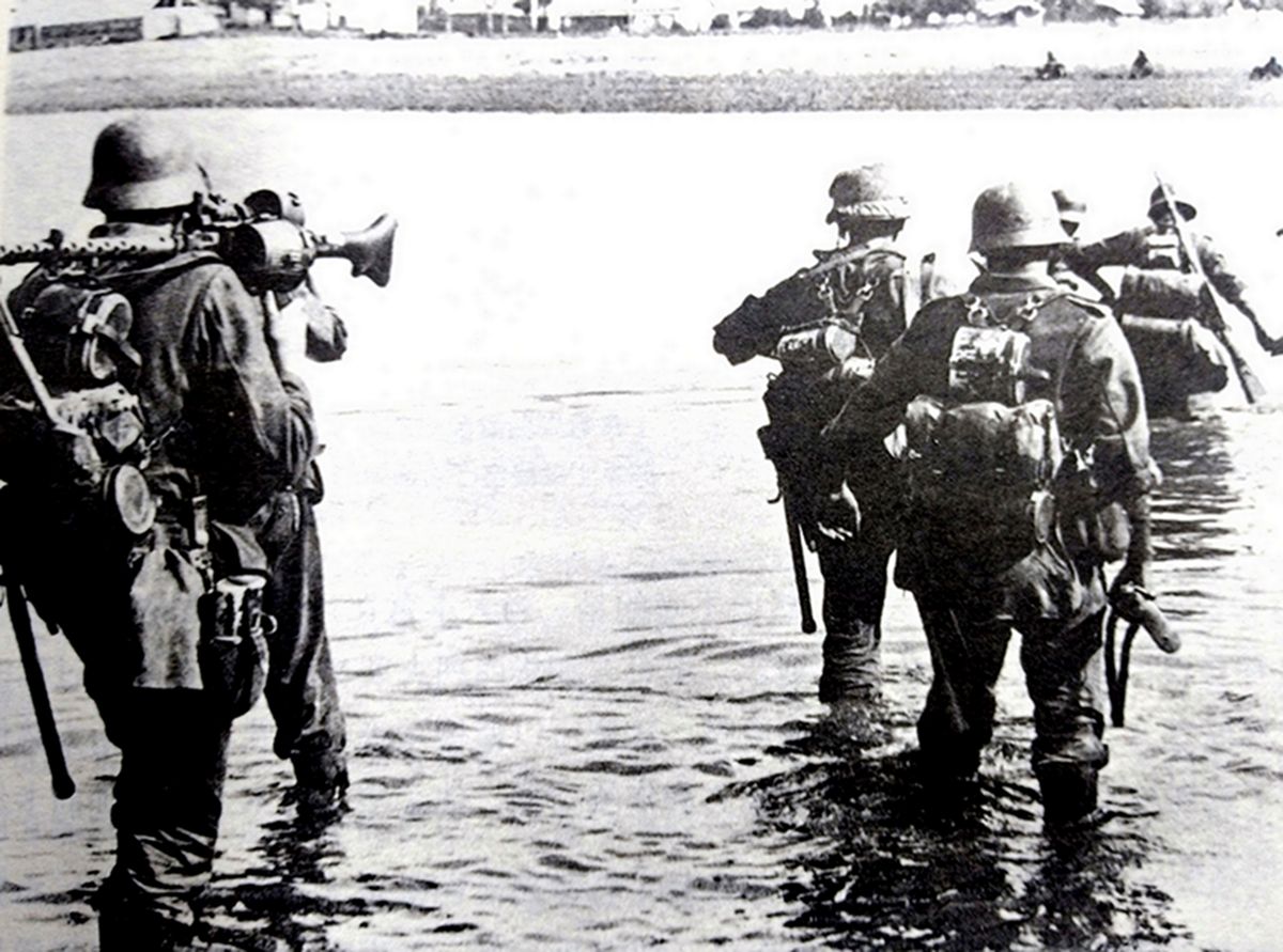 1942年，东线苏联战场高加索地区，德军一个步兵班正在涉水过河。注意：机枪手扛着的那挺MG34机枪装的是一个50发弹匣，这对机枪手来说，行军时会比较方便，但在战斗中，德军会更多使用50/250发的子弹链。
