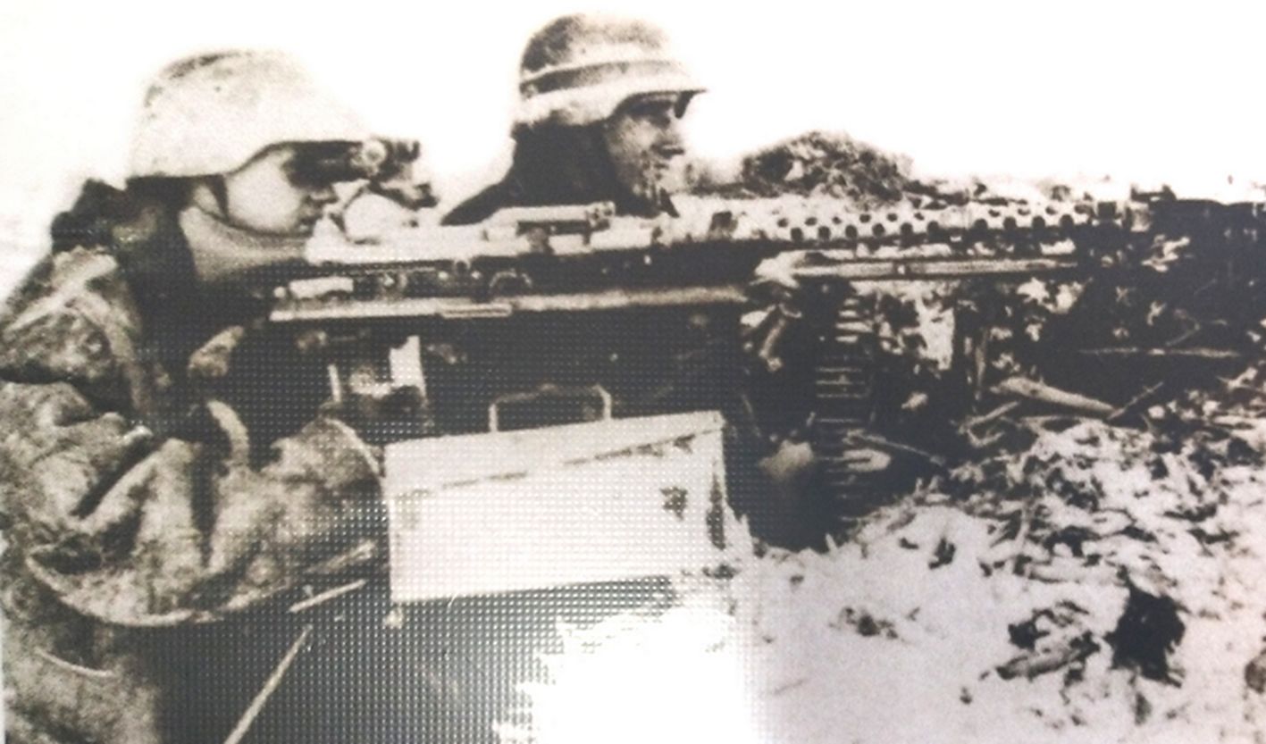 1941年冬天，东线苏联战场，进攻莫斯科的德国中央集团军群已转入防御，面对苏军即将到来的反攻，一个武装党卫军的MG34重机枪组在防御阵地上作好了战斗准备，机枪射手用望远镜观察着前方动静，机枪旁放着的弹药箱，弹药手也紧张地注视着前方。