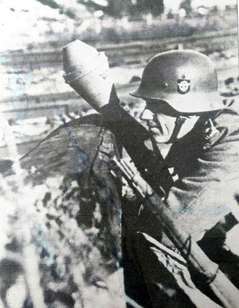 1945年,在德国某城市,一名德国党卫军宪兵部队的士兵正手持铁拳60反坦克榴弹发射器抗击进攻的苏军坦克。在柏林战役中,苏联第2坦克军共有287辆T-34坦克被摧毁,其中有67辆是被铁拳反坦克榴弹所摧毁,可见铁拳也是有一定反坦克战力的。