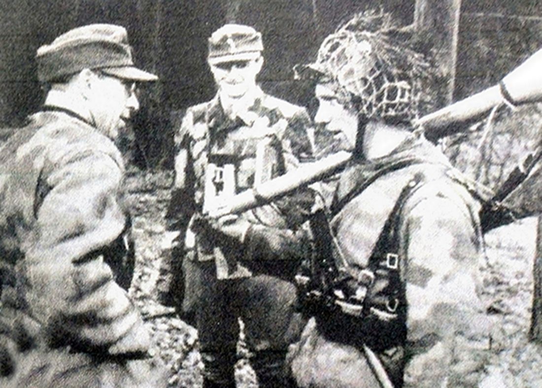 一名肩扛铁拳60反坦克榴弹发射器的德军士兵正在接受军官的命令。在二战后期,铁拳已成为德军单兵配备的主要反坦克武器。