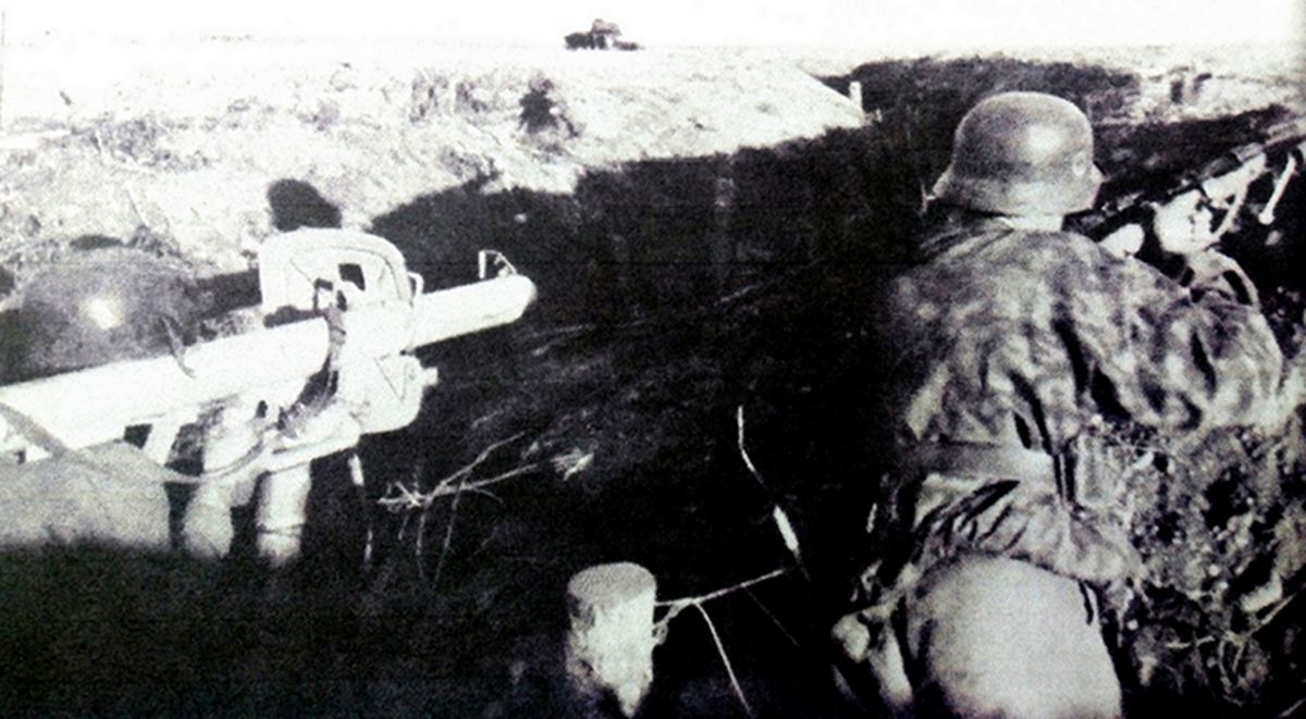 东线苏联战场,两名德军士兵正在战壕中抵御苏军进攻,一名士兵拿着步枪,另一名士兵拿着「坦克杀手」反坦克火箭筒。