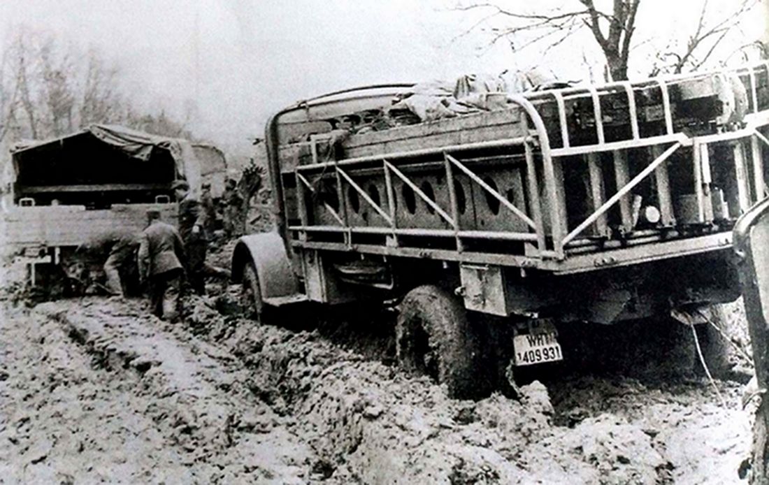 1942年，东线苏联战场，一队德军卡车陷进泥泞路上进退不能，最后一辆是装载着工兵桥梁的奔驰4500A重型军用卡车。