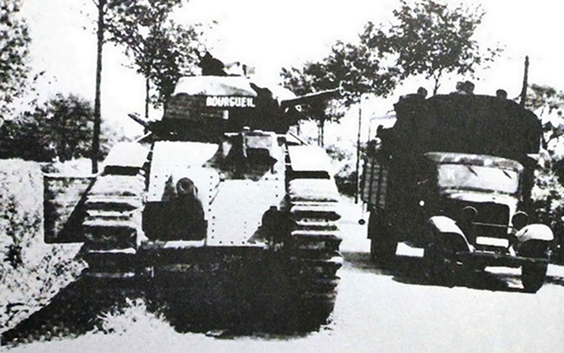 1940年，西线法国战场，一辆福特FORD BB中型军用卡车（1937年版）正从一辆德军Ⅰ号B型坦克旁边经过。注：福特FORD BB中型军用卡车有效载荷2.5吨，采用FORD BB发动机，功率52马力，最高时速为75公里。