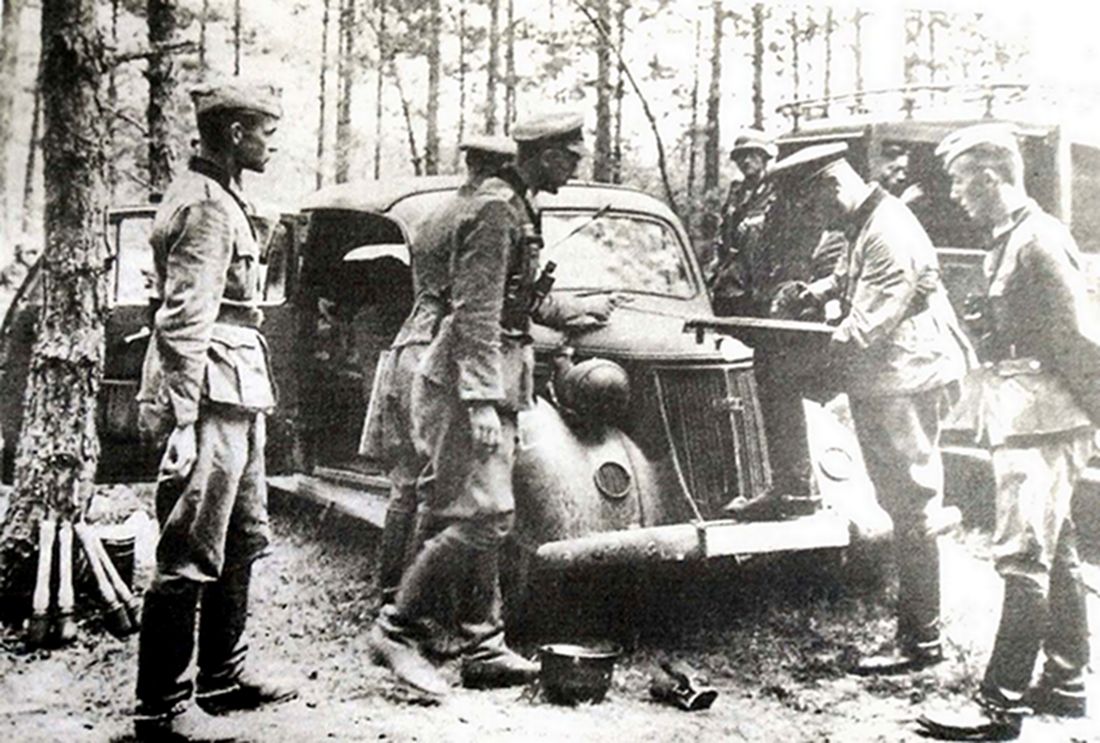 1941年夏天，东线苏联战场，德军第6装甲师指挥官座车（Kfz.17），该车隐蔽在树林中，师部军官们正在车外研究作战方案。