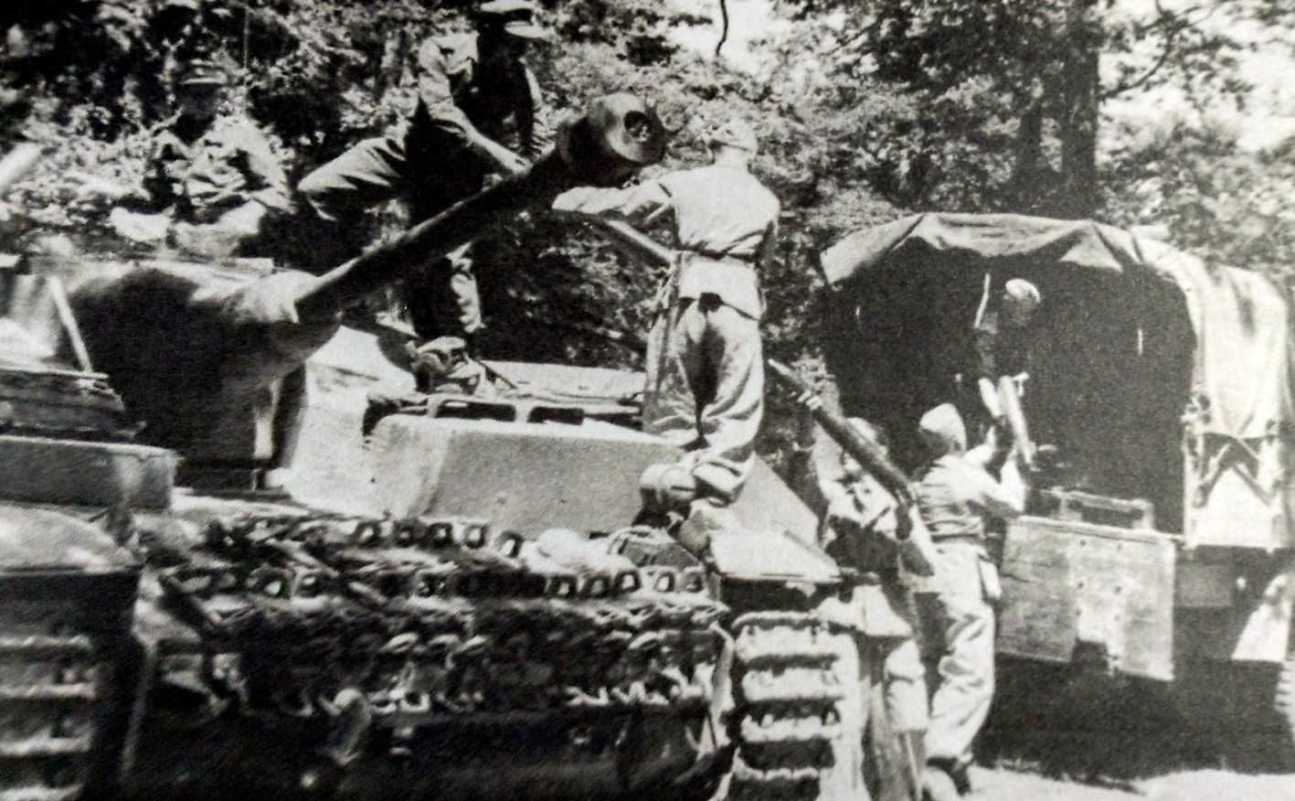 1944年春天,意大利,德军正从运输车上将炮弹传递到914突击旅的一辆Ⅳ号自行突击炮车内进行弹药补充。