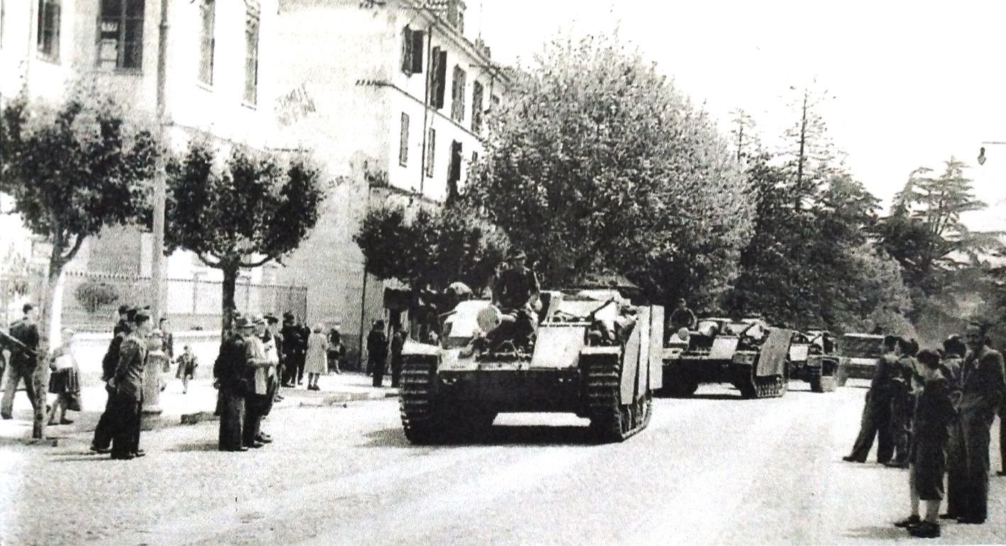 1945年5月,意大利伊夫雷亚,隶属于德军34步兵师第34装甲营的StuG Ⅳ式突击炮正在街道上驶过。注意其驾驶员位置前方加装的附加装甲。