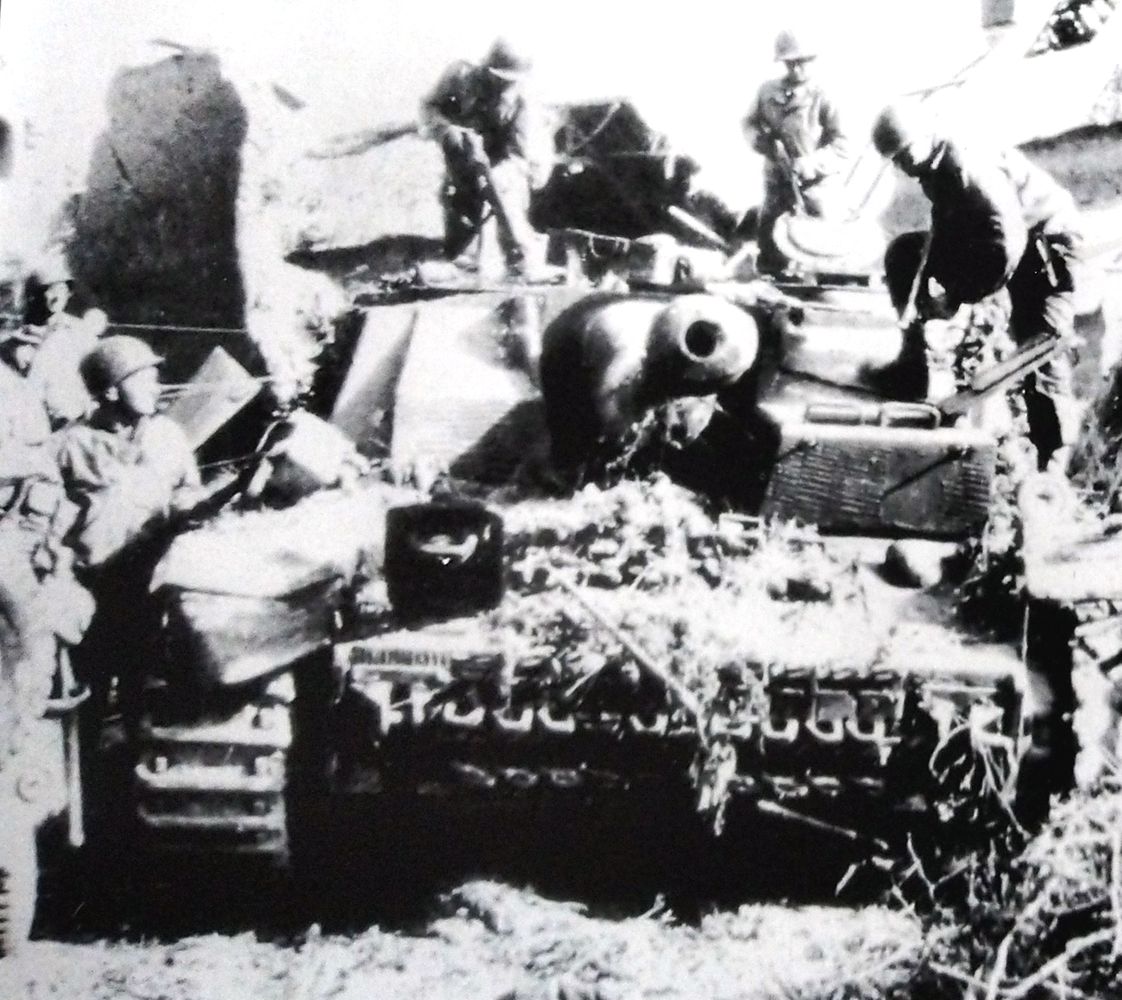 1944年7月底,法国战场上一辆被德军遗弃的Ⅳ号自行突击炮车,几名美军士兵正在对其进行检查。